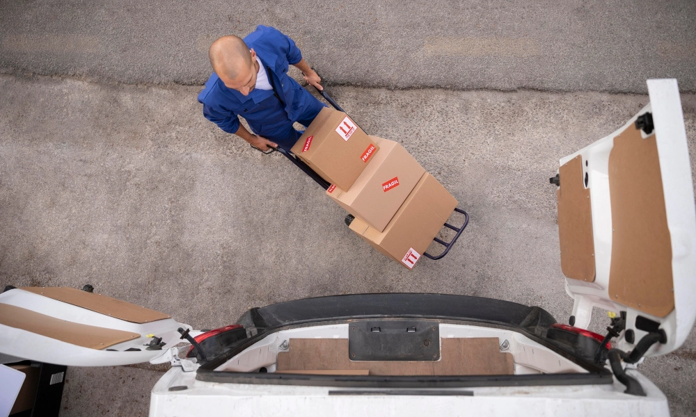 Persona subiendo paquetes a una van